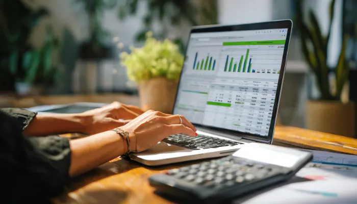 Person reviewing financial data on laptop with charts