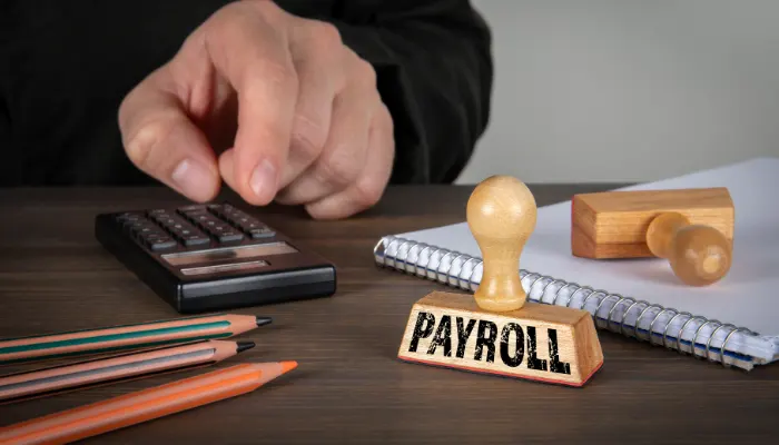 Payroll stamp with calculator and office supplies